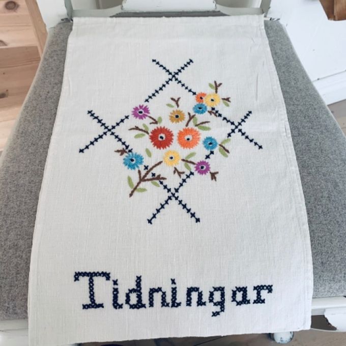 Tidningsupphäng broderat
